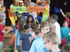 Alle Kinder gehen durch das Schultor.